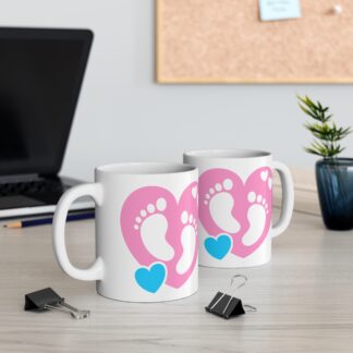11oz Ceramic Mug. Pink Heart with baby foot prints inside and a blue heart.